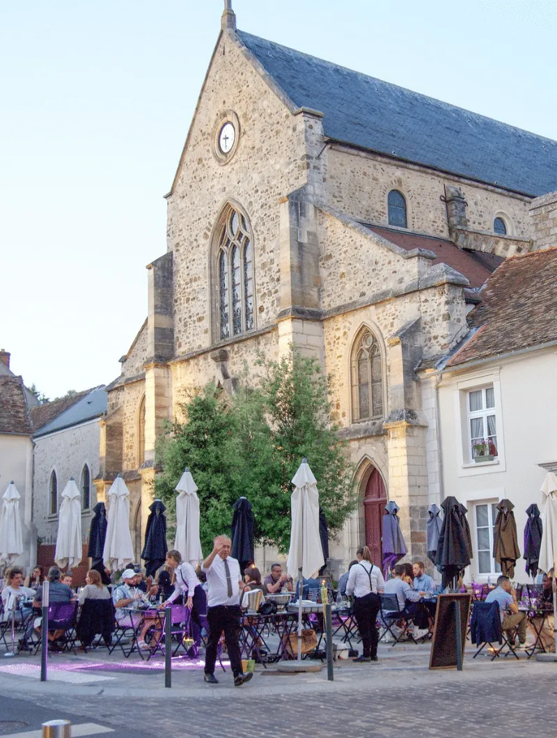 Terrasse de L'Ardoise Restaurant à l'ombre de l'église Saint-Clément d'Arpajon